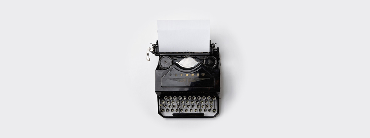 An old typewriter with a sheet of paper on top, symbolizing timeless communication and creative expression.